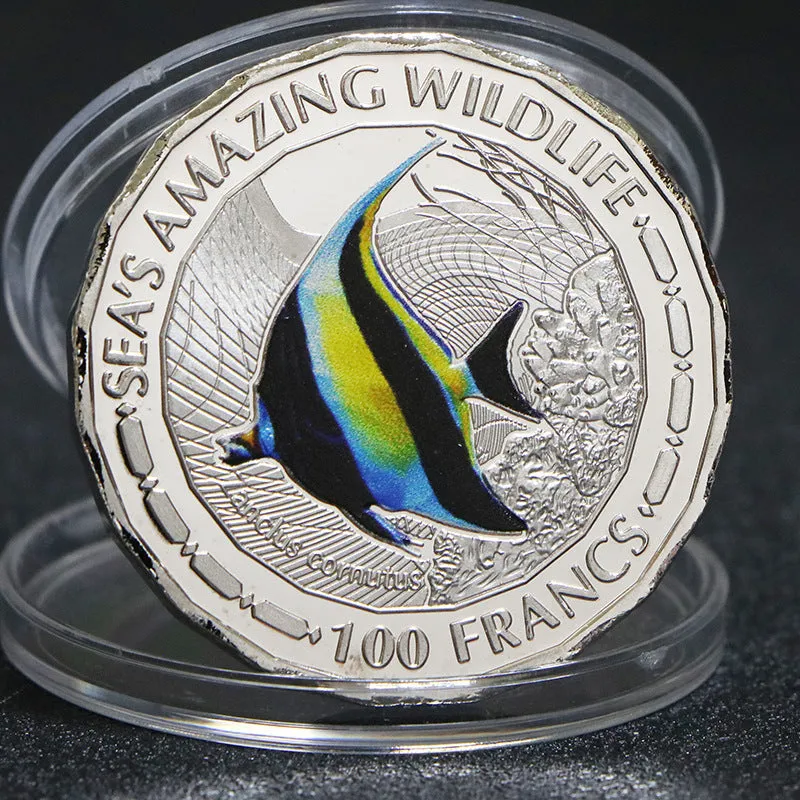 Set of eight silver plated commemorative coins with tropical fish and marine animal designs, 40mm diameter, in acrylic box