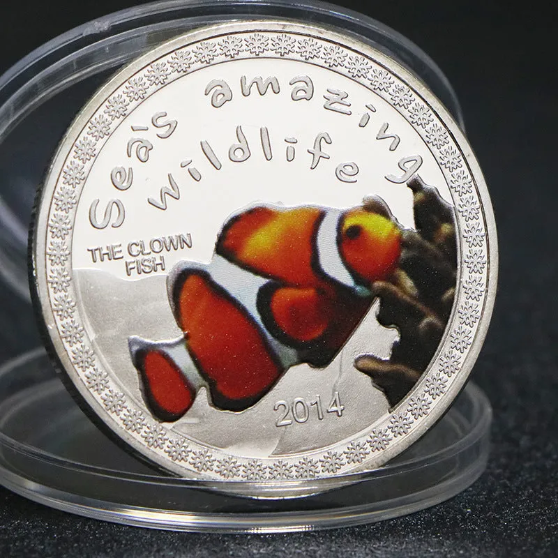 Set of eight silver plated commemorative coins with tropical fish and marine animal designs, 40mm diameter, in acrylic box