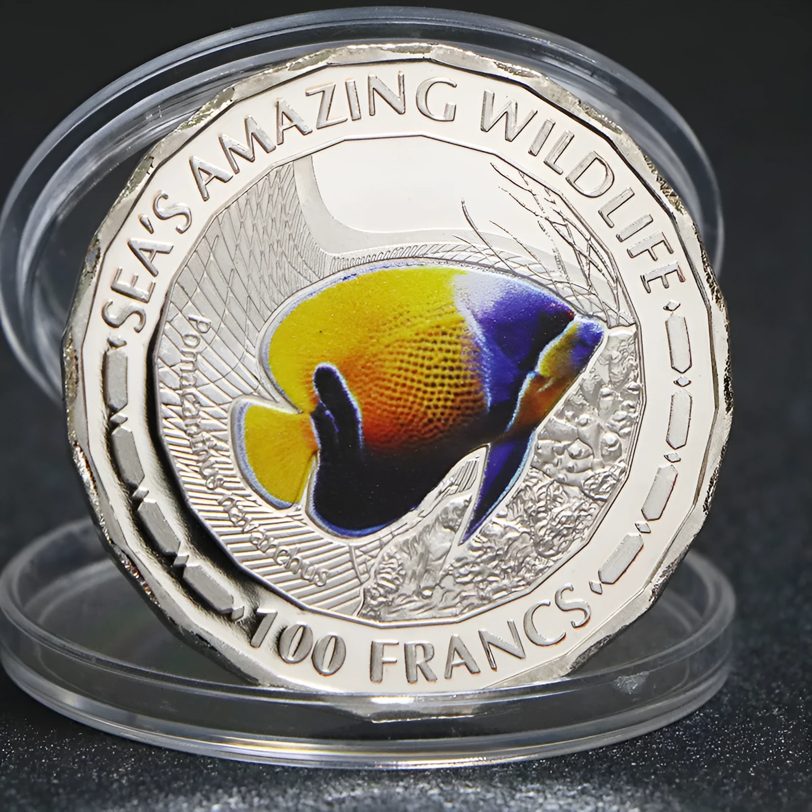 Set of eight silver plated commemorative coins with tropical fish and marine animal designs, 40mm diameter, in acrylic box