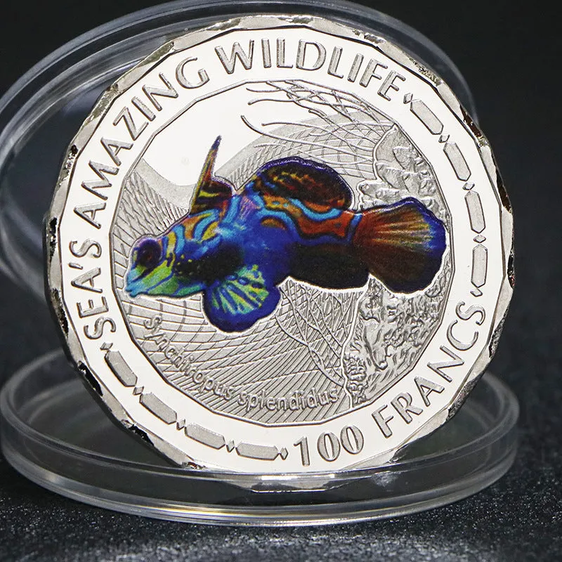 Set of eight silver plated commemorative coins with tropical fish and marine animal designs, 40mm diameter, in acrylic box