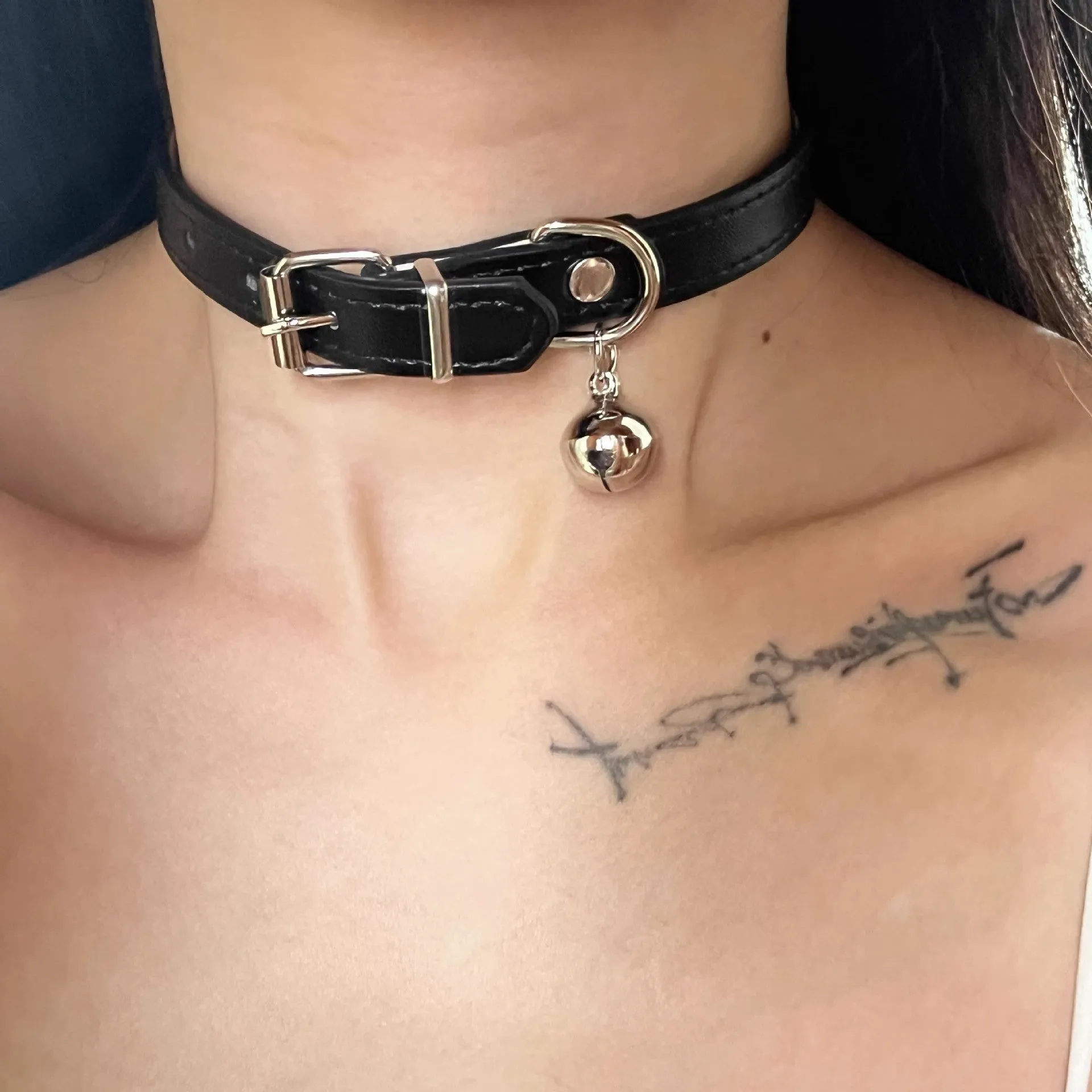 Black adjustable leather dog collar with decorative bone charm on a regular chain