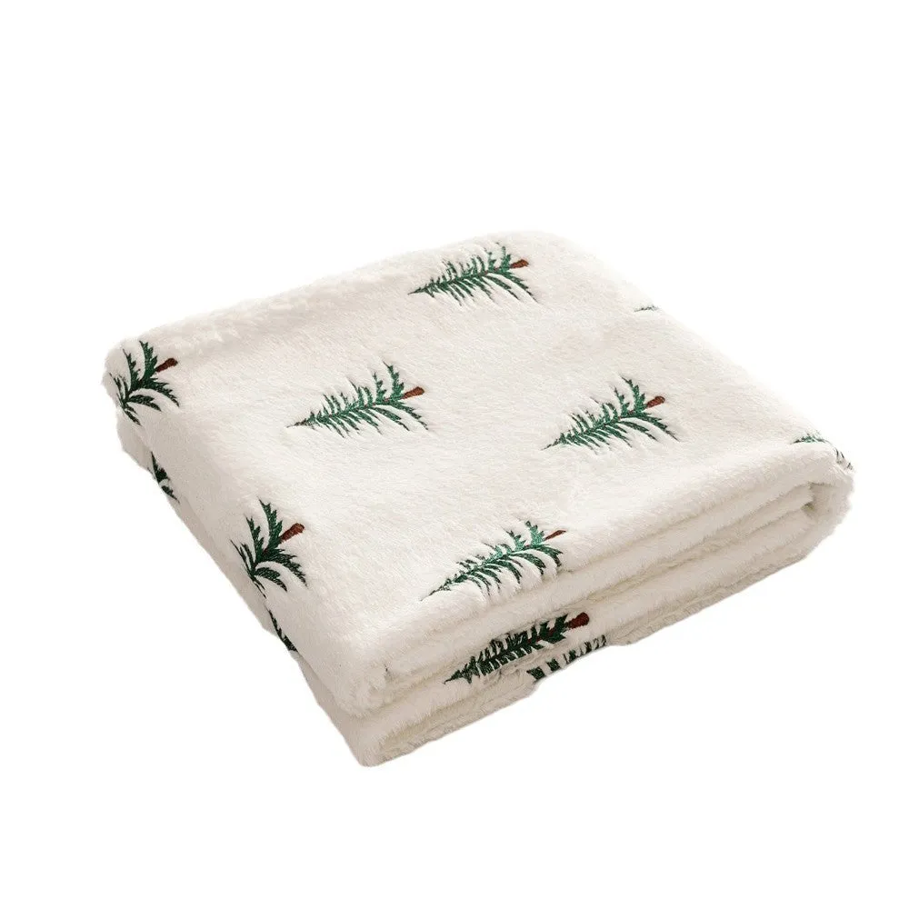 White polyester Christmas plush sofa blanket with embroidered Christmas tree design on a sofa