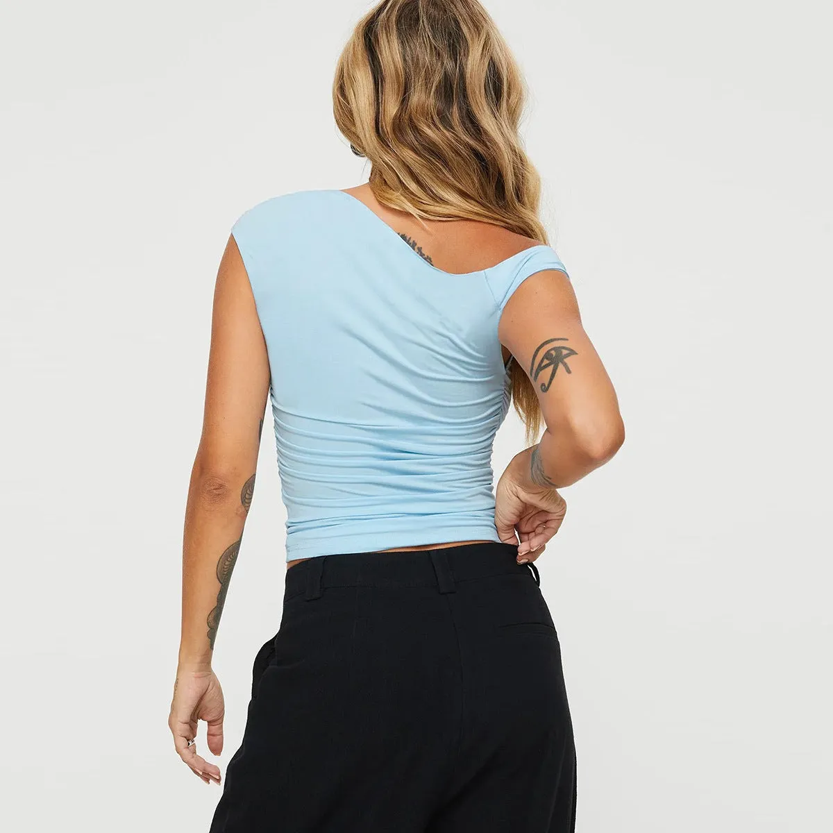 Women's light blue sleeveless oblique collar pleated slim-fit top on model