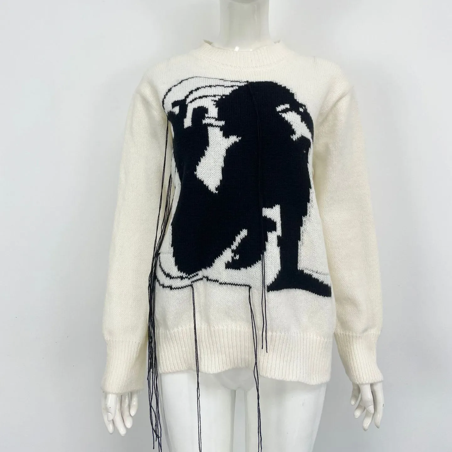 Grey loose women's alpaca wool pullover sweater with tassel detail on a hanger.
