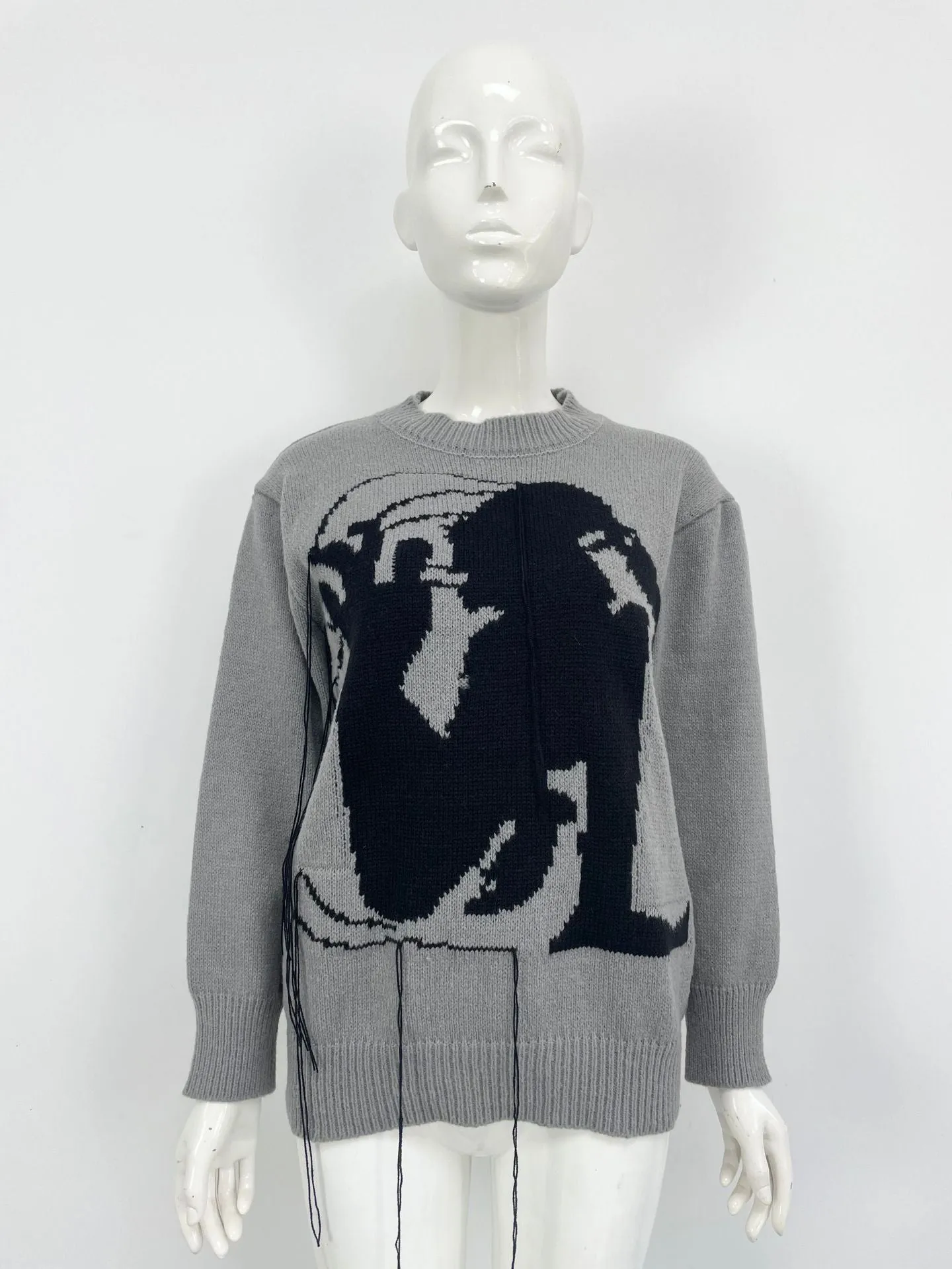 Grey loose women's alpaca wool pullover sweater with tassel detail on a hanger.