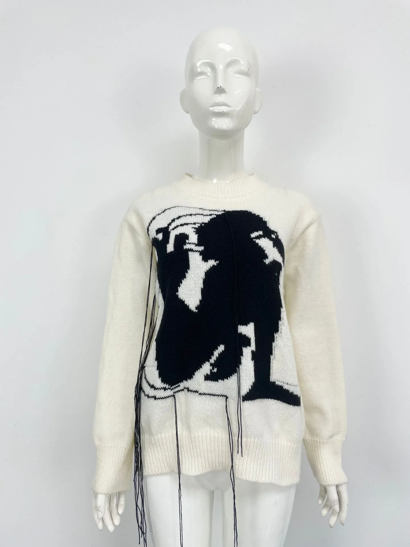 Grey loose women's alpaca wool pullover sweater with tassel detail on a hanger.