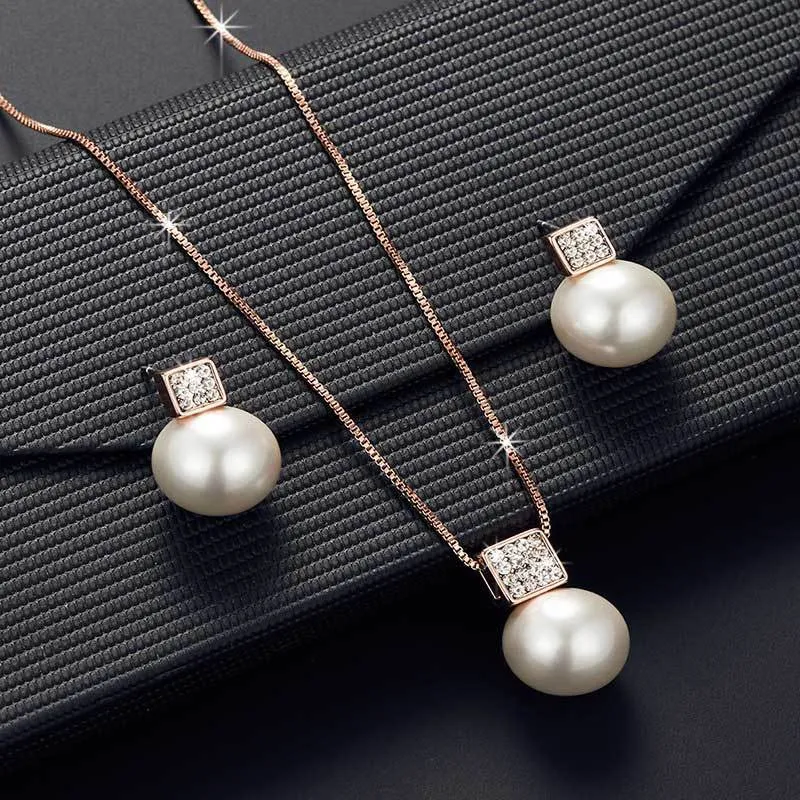 Versatile jewellery set with necklace and earrings featuring rhinestone cube pendants in rose gold finish