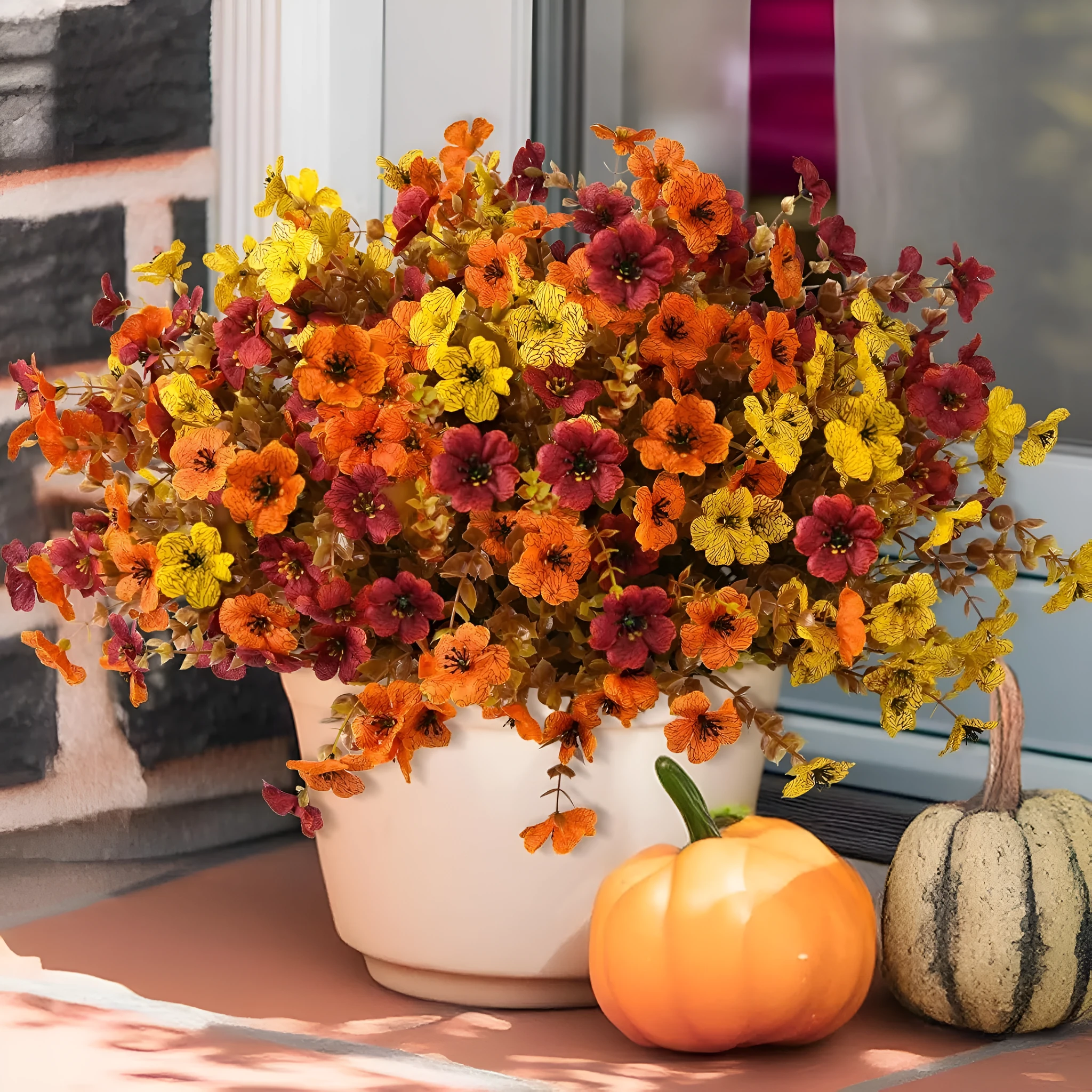 Artificial flower bouquet in autumn colours of red, yellow, and orange for home and event decoration.