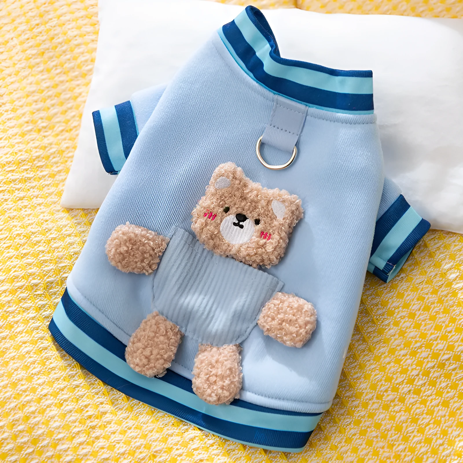 Soft navy blue dog sweater with light blue striped cuffs and blush bear decorations