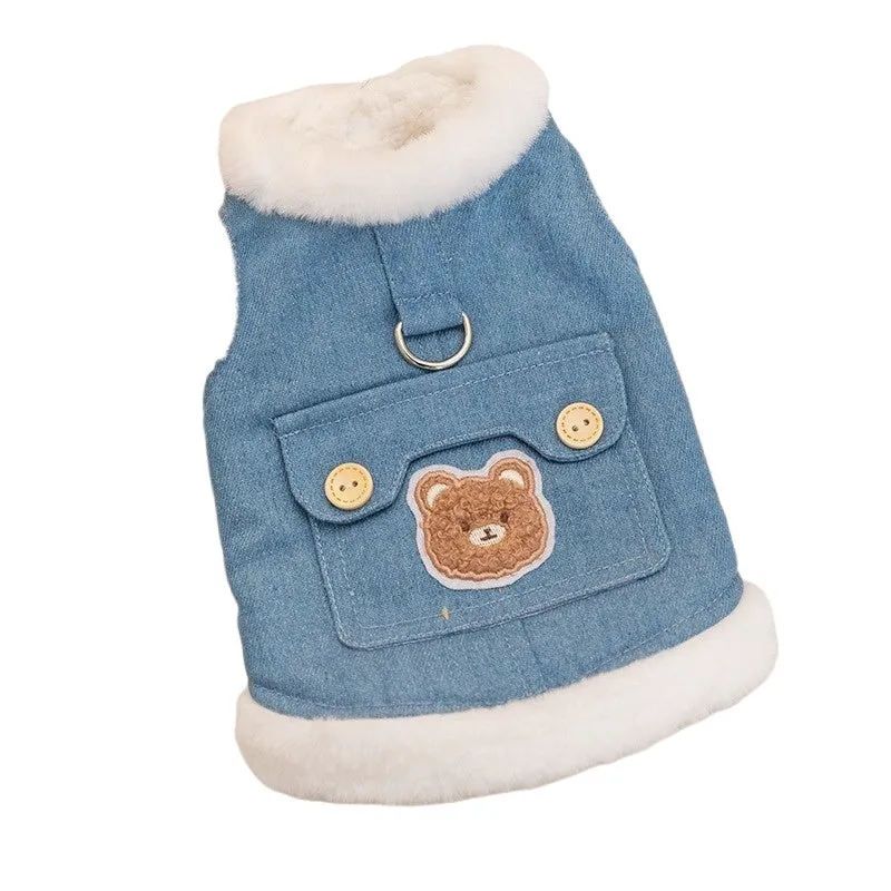 Denim dog vest with white wool lining, embroidered teddy bear patches, wooden buttons, and metal D-ring on blue background
