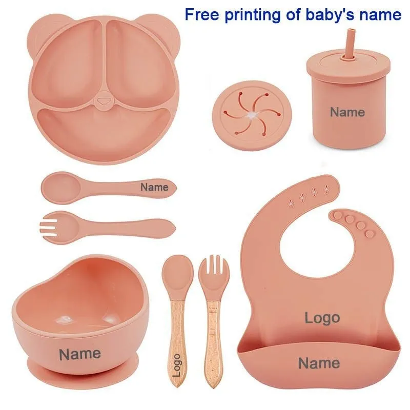 Children's silicone tableware set with cat ear cup in beige, blue and other colours on a table