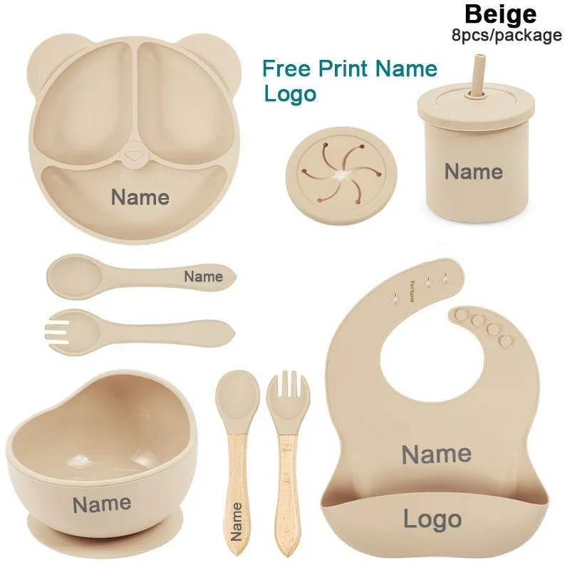 Children's silicone tableware set with cat ear cup in beige, blue and other colours on a table