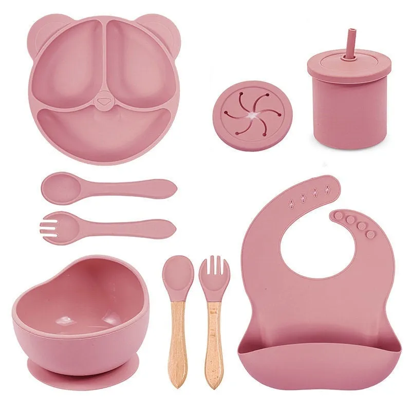 Children's silicone tableware set with cat ear cup in beige, blue and other colours on a table