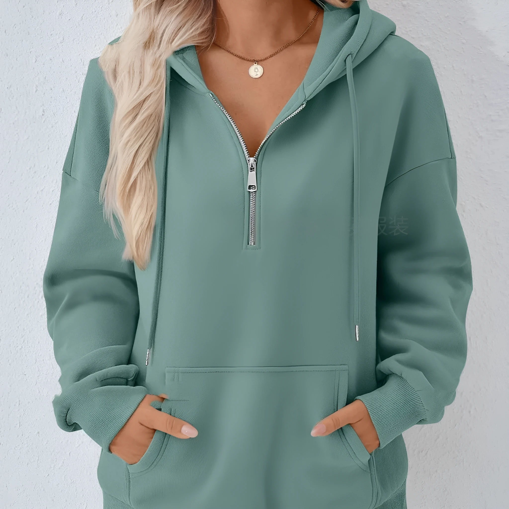 Polyester pullover hooded sweatshirt in peacock green with zip pocket on front. Long sleeve, solid colour, casual style.