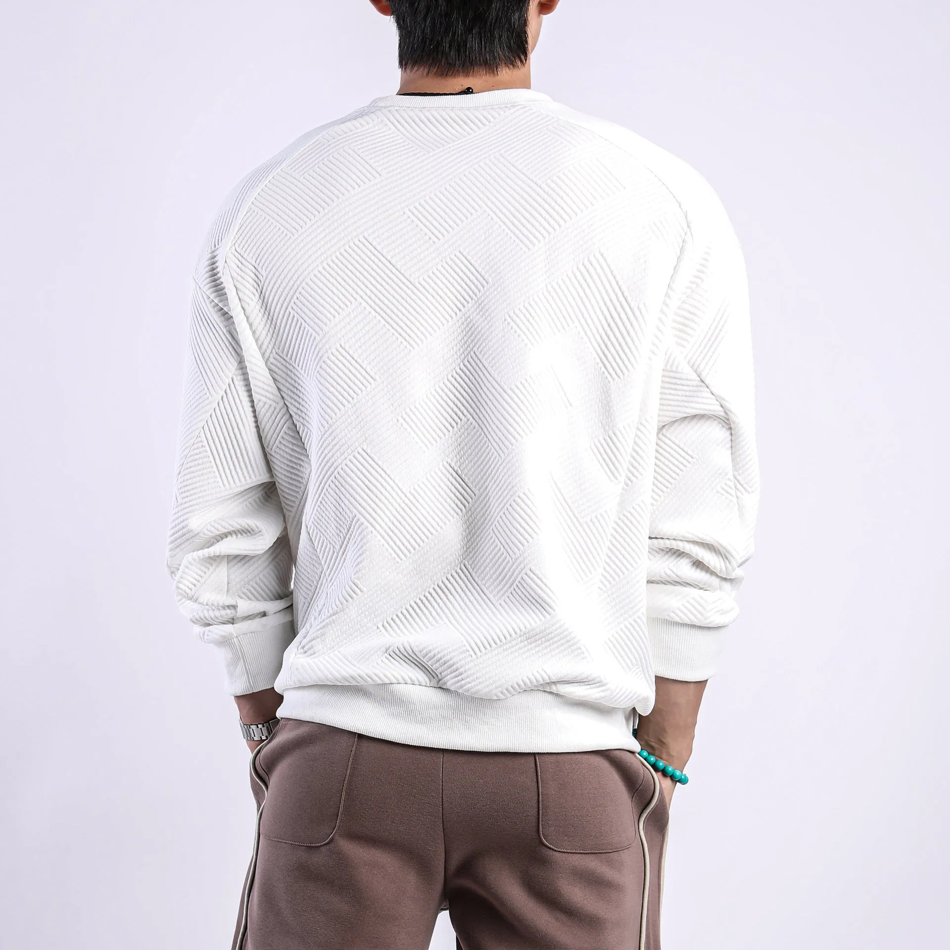 Men's loose fit solid colour twill jacquard pullover sweater on a hanger.