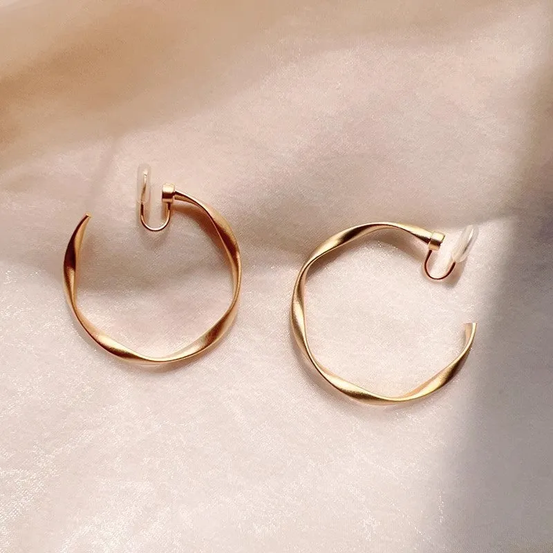 Rotatable circle mosquito coil ear clip in matte gold with rubber pads for women