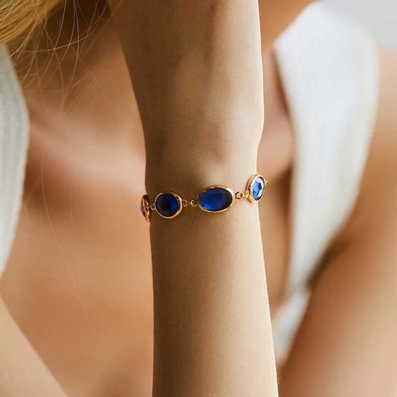 Geometric copper bracelet with blue inlaid glass elliptical design for women.