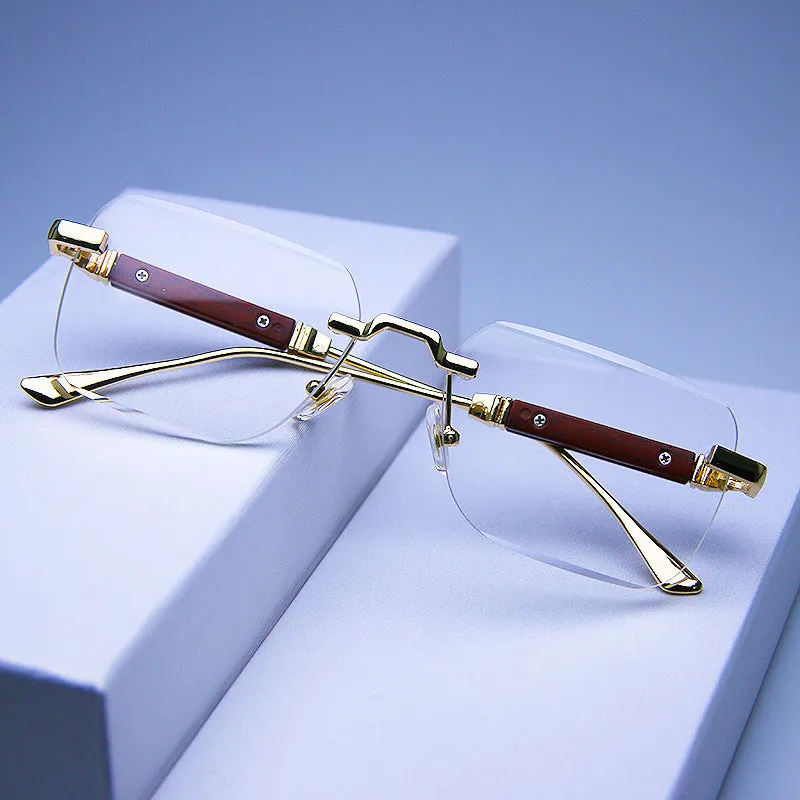Frameless edge-cut sunglasses with gold frame, wood grain legs, and gradient grey lenses on a neutral background