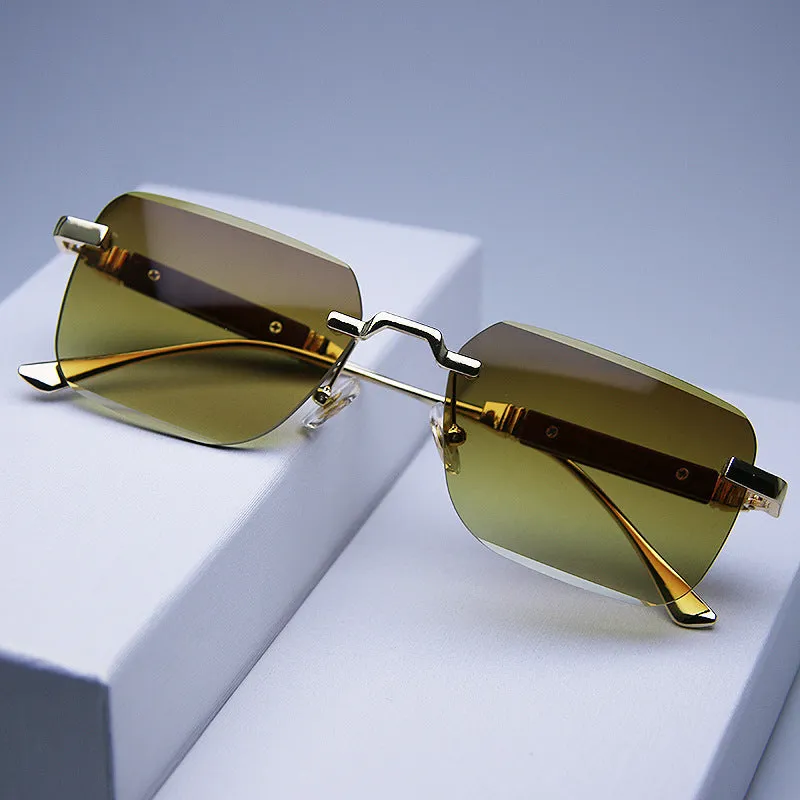 Frameless edge-cut sunglasses with gold frame, wood grain legs, and gradient grey lenses on a neutral background