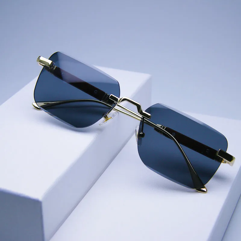 Frameless edge-cut sunglasses with gold frame, wood grain legs, and gradient grey lenses on a neutral background