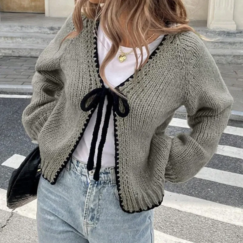 Grey lace-up sweater cardigan with long sleeves and crocheted flower decoration on the front.