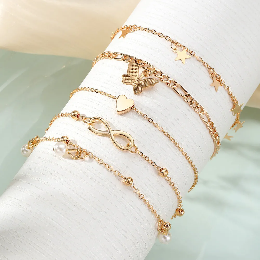 Four-piece women's alloy anklet set with butterfly and pearl heart charms in multi-layer design