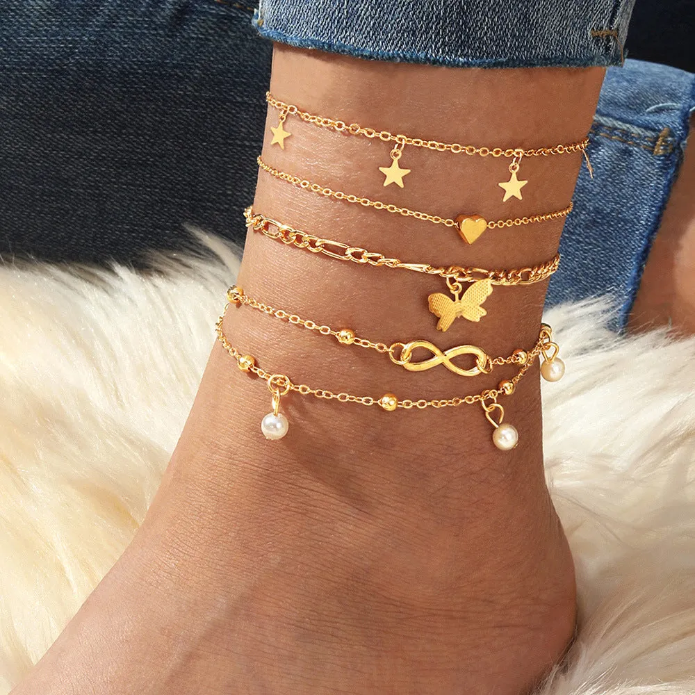 Four-piece women's alloy anklet set with butterfly and pearl heart charms in multi-layer design