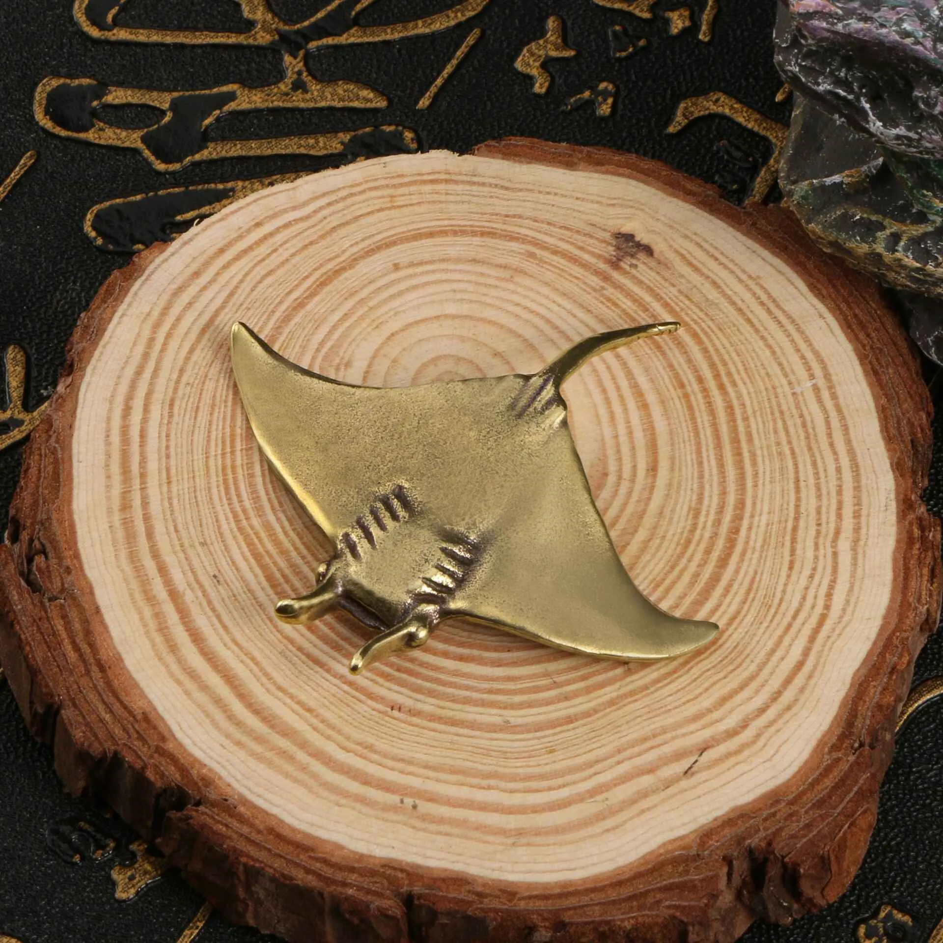 Brass devil fish ornament figurine on a surface, showing metallic colour and intricate devil fish design