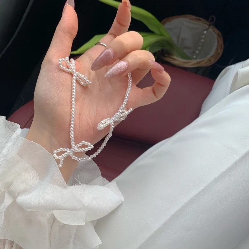 White bow pearl necklace with geometric clasp on woman at clavicle length