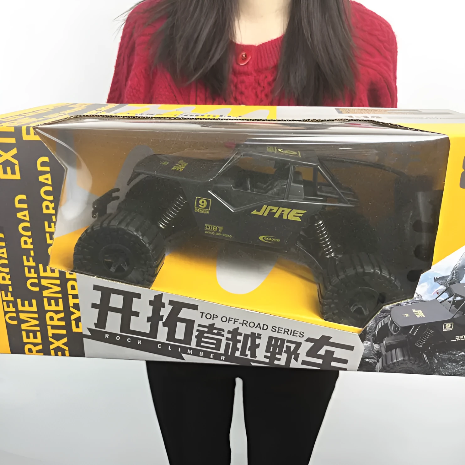Super large black remote control off-road toy car with four-wheel drive and spring rod design on outdoor ground