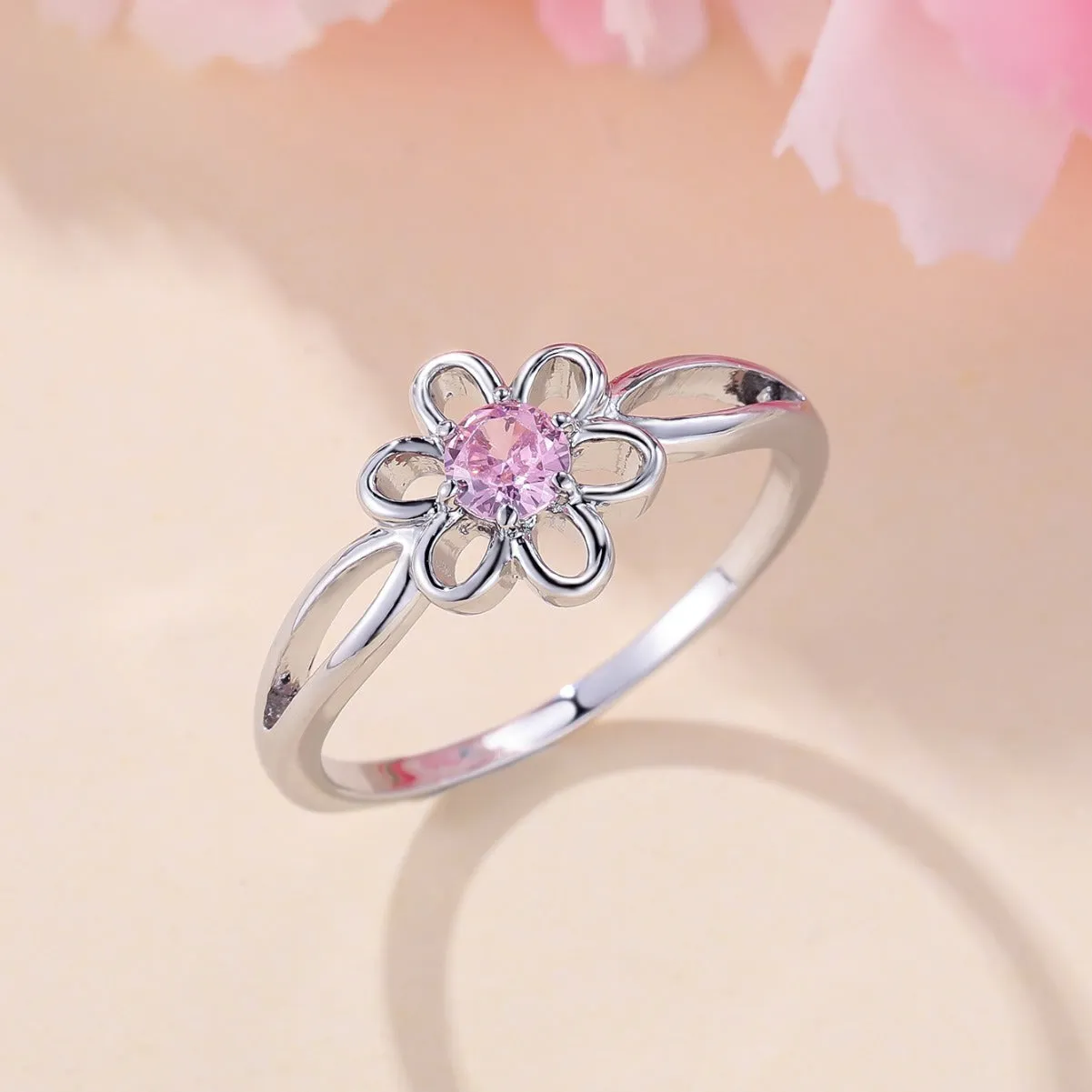 Women's hollowed flower fashion ring in electroplated platinum pink diamond colour on a white background.