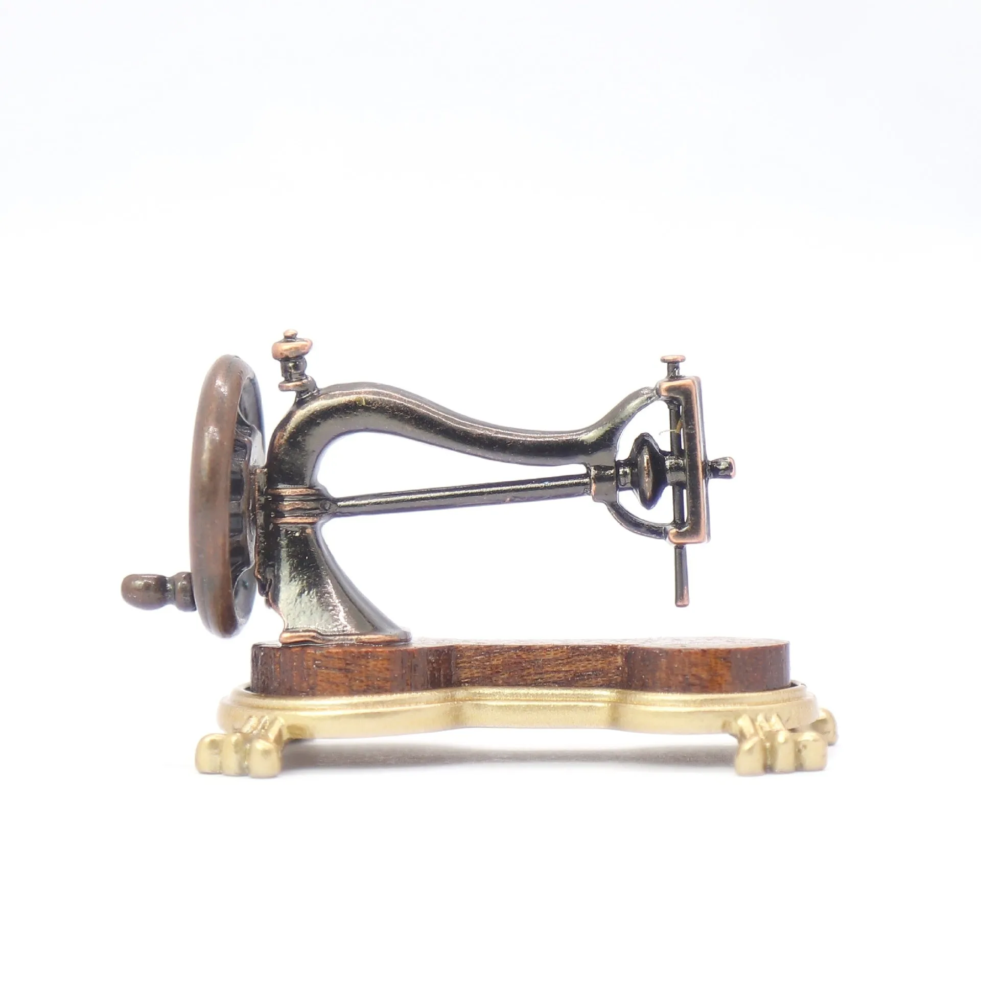 Brown metal simulation mini hand sewing machine dollhouse accessory on display