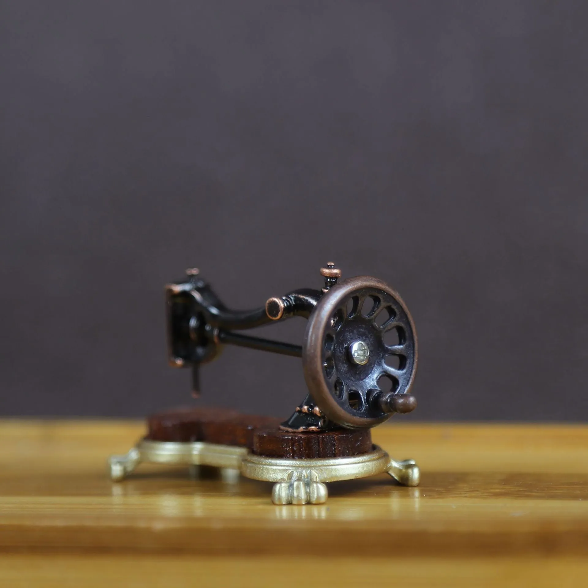 Brown metal simulation mini hand sewing machine dollhouse accessory on display