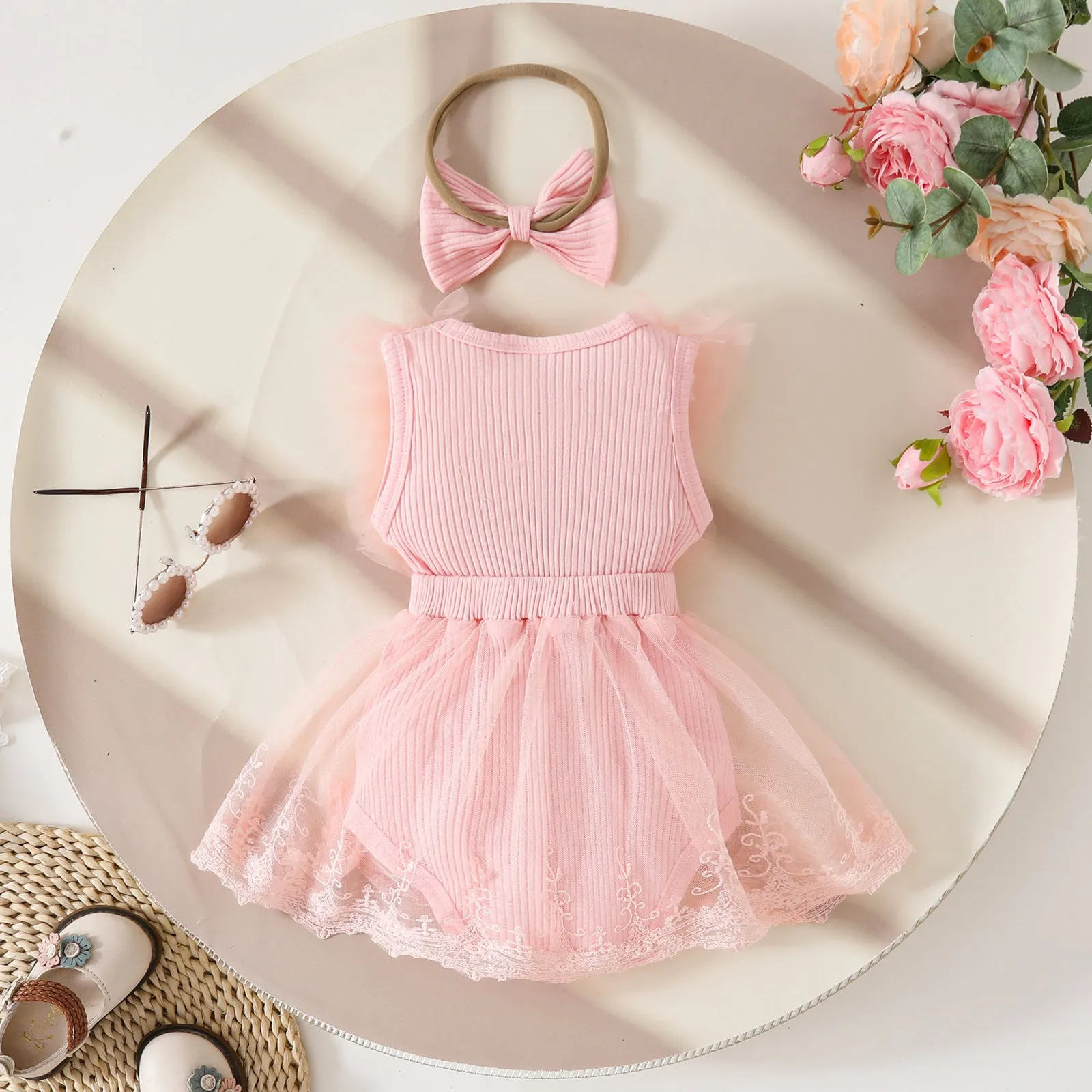Baby girl in white triangle jumpsuit leotard with sweet bow hair band