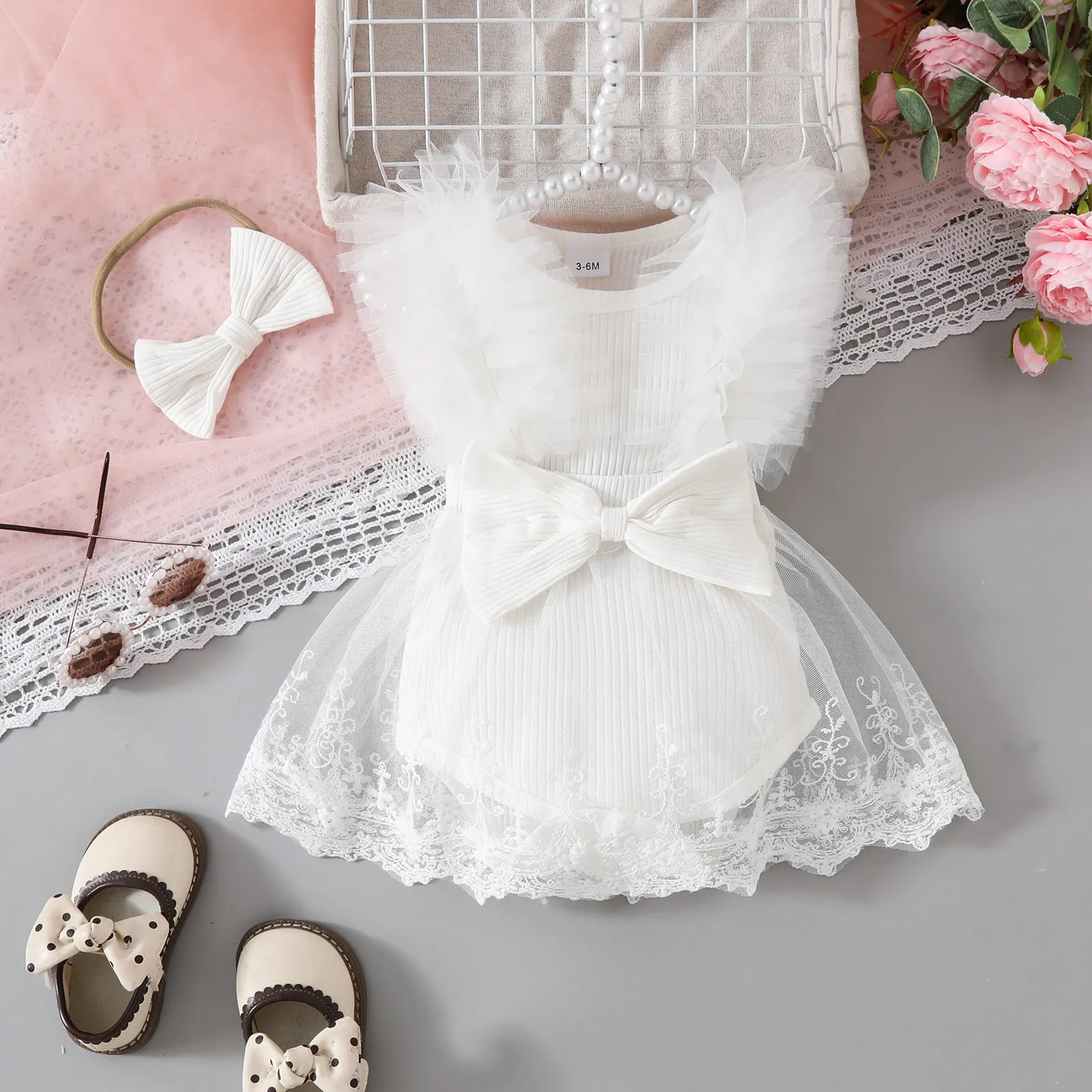 Baby girl in white triangle jumpsuit leotard with sweet bow hair band