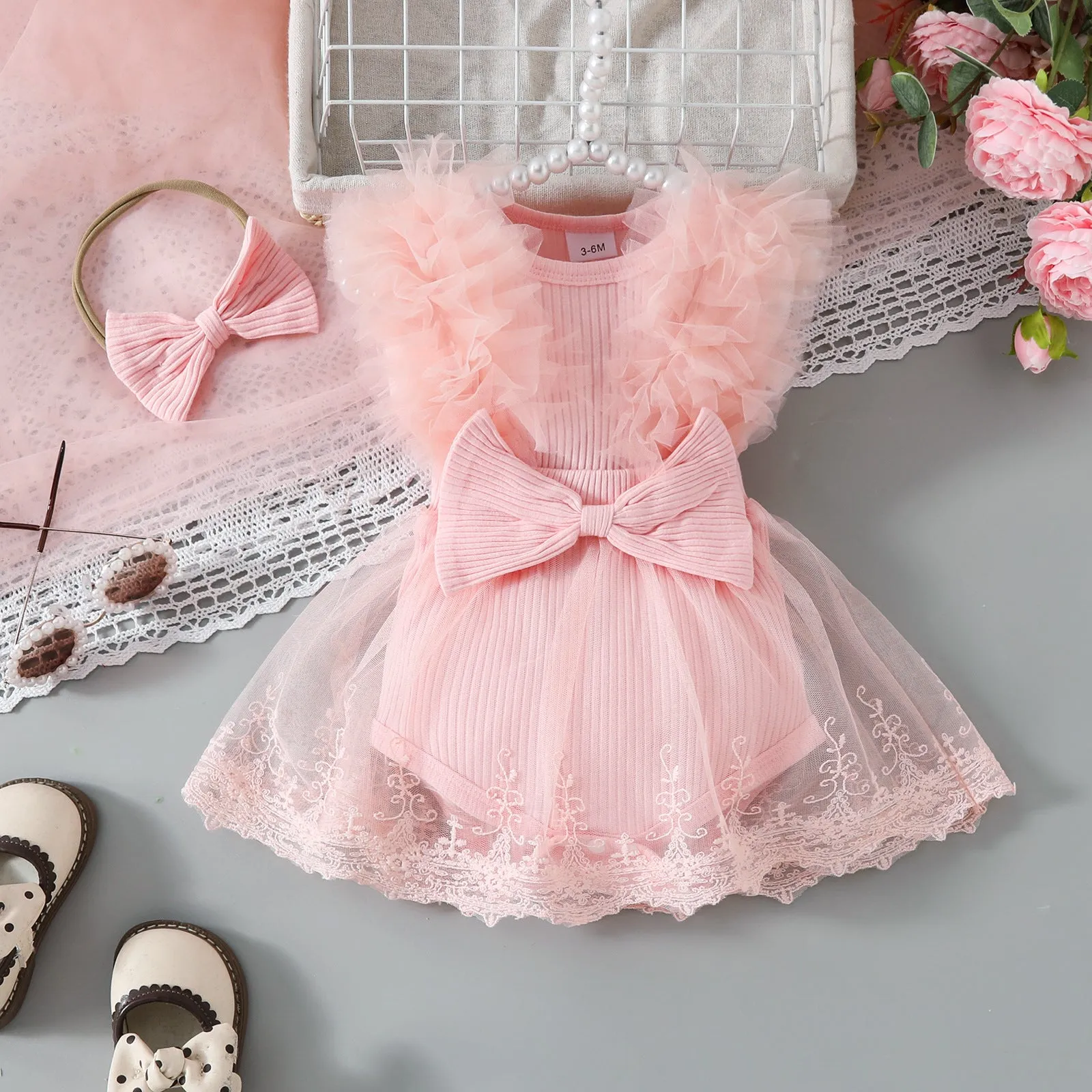 Baby girl in white triangle jumpsuit leotard with sweet bow hair band