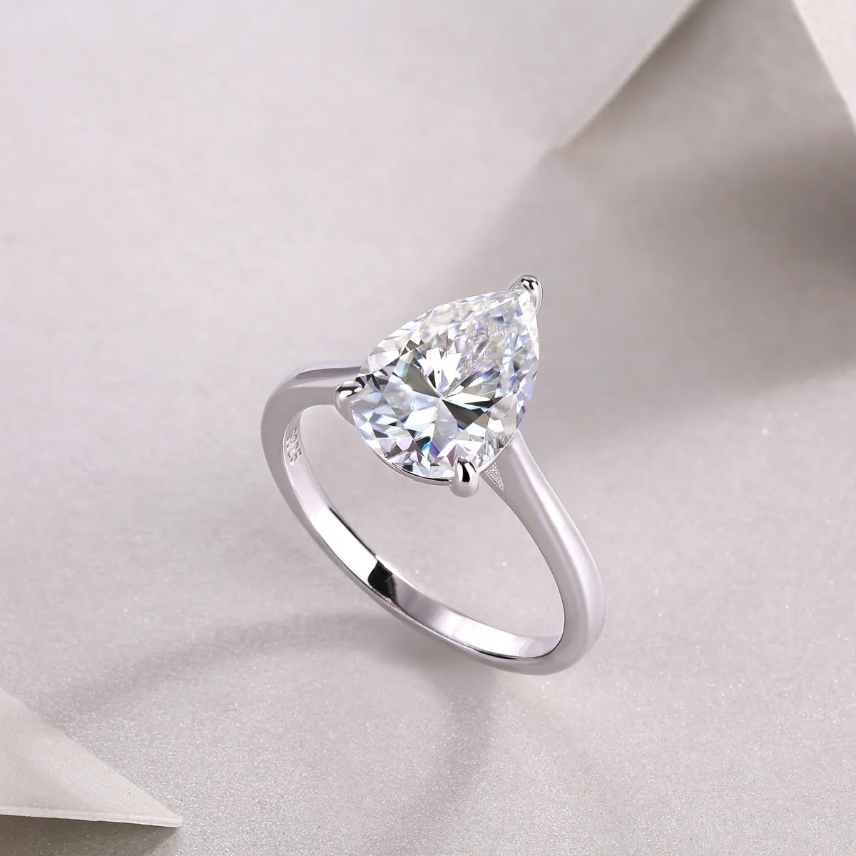Heart-shaped pear-cut moissanite wedding ring set in S925 silver with platinum plating on white background