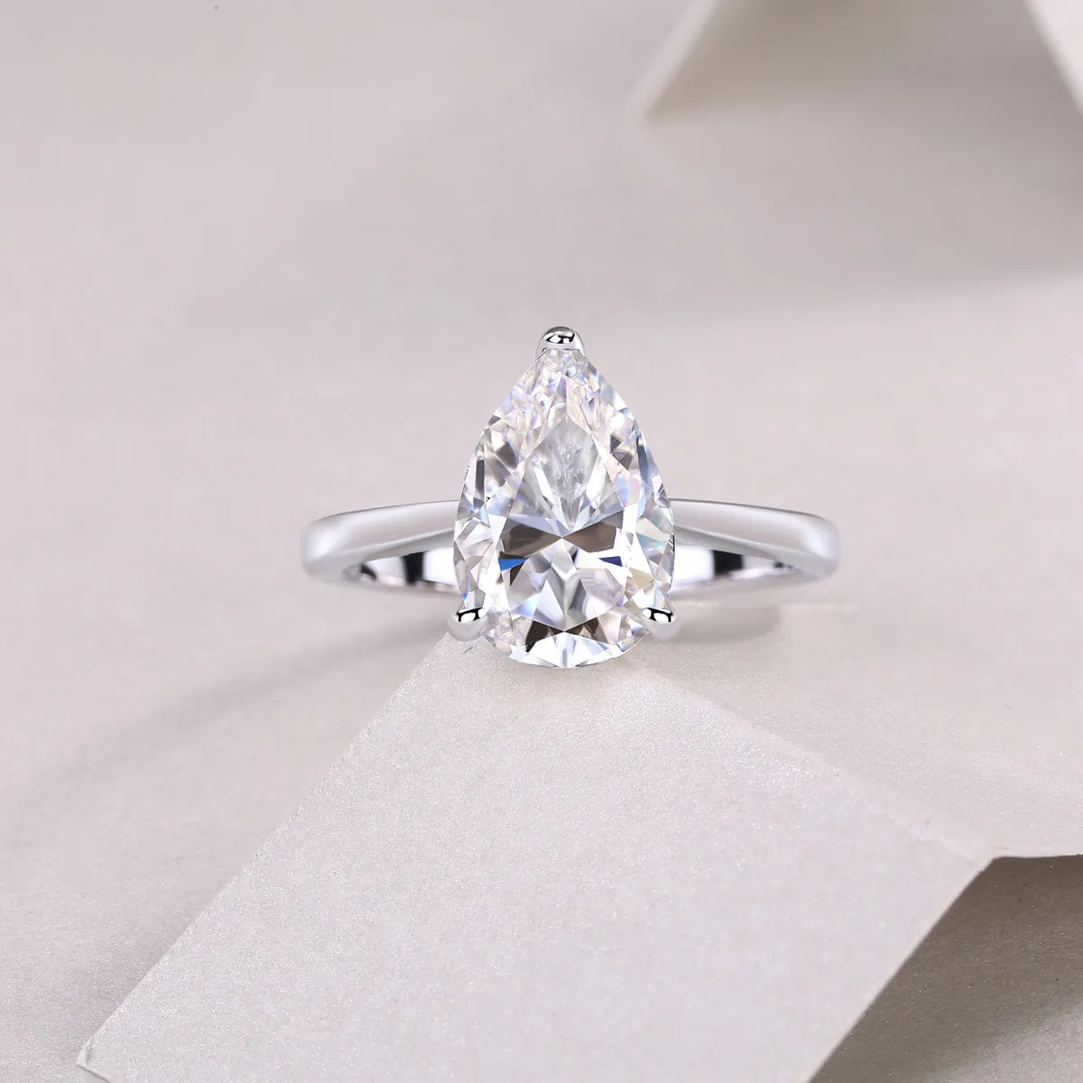 Heart-shaped pear-cut moissanite wedding ring set in S925 silver with platinum plating on white background