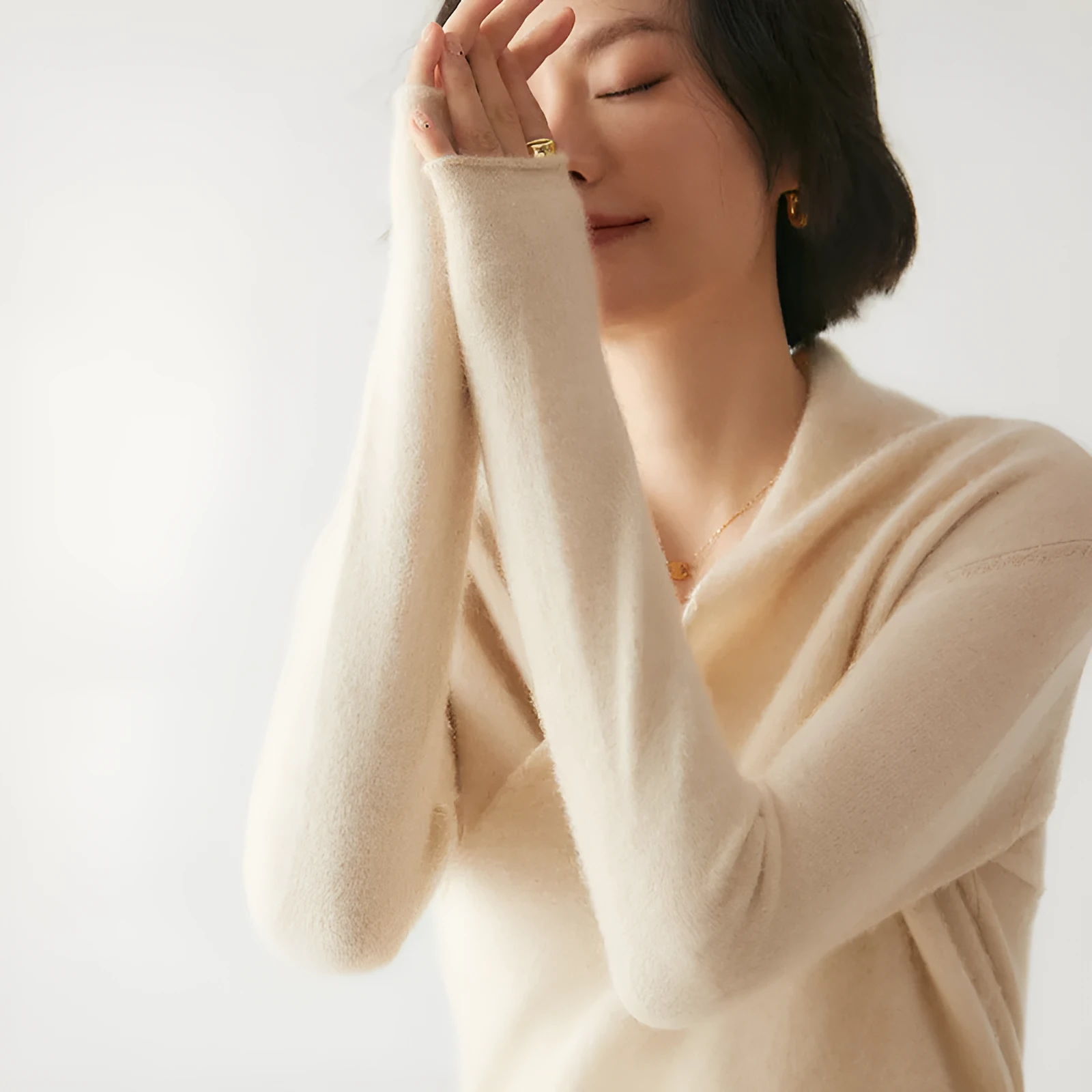 Women's solid colour cashmere V-neck cross sweater top with long sleeves in Elegant Camel, shown on a model.