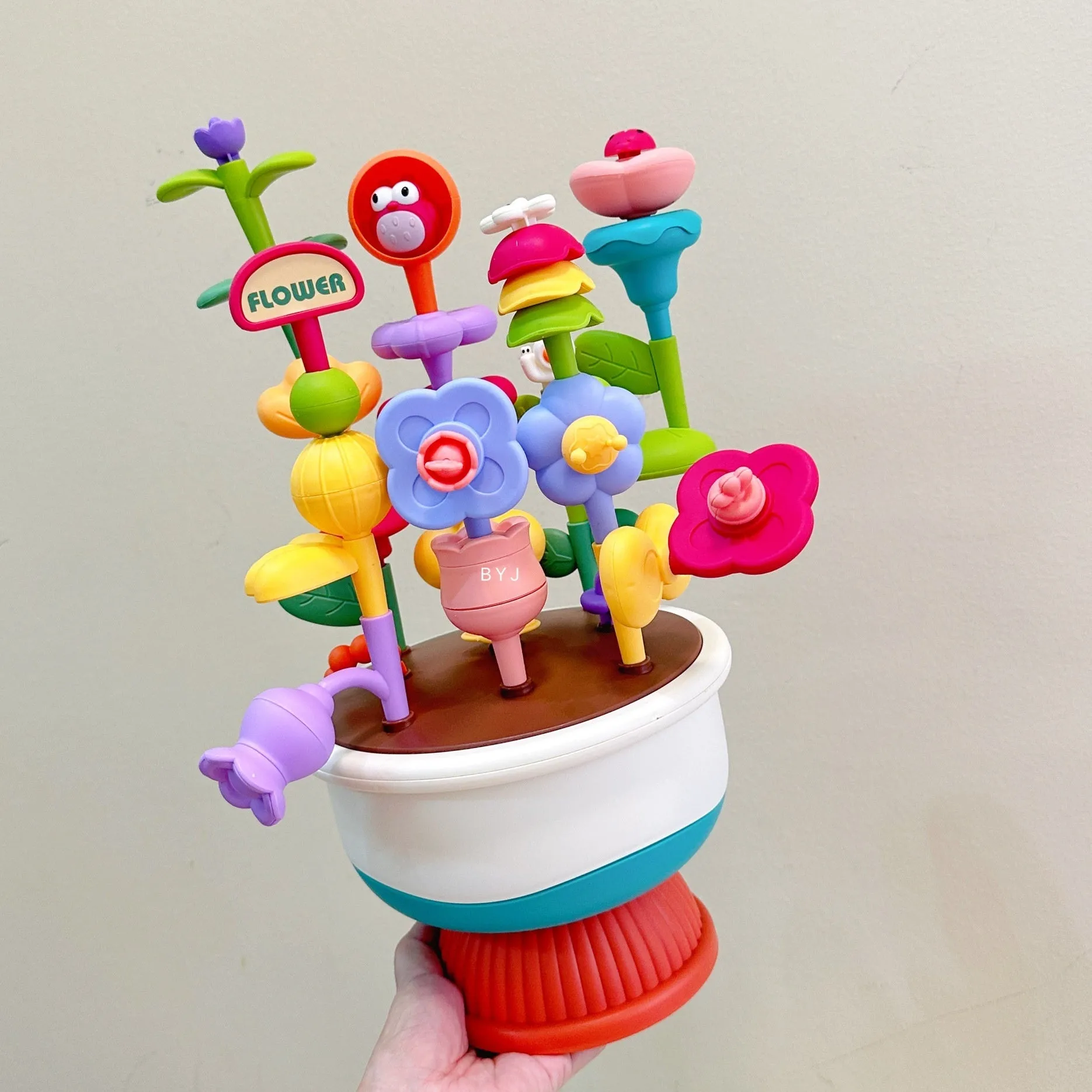 Colourful plastic flowerpot building block set with assorted flower-shaped pieces, in a colour box