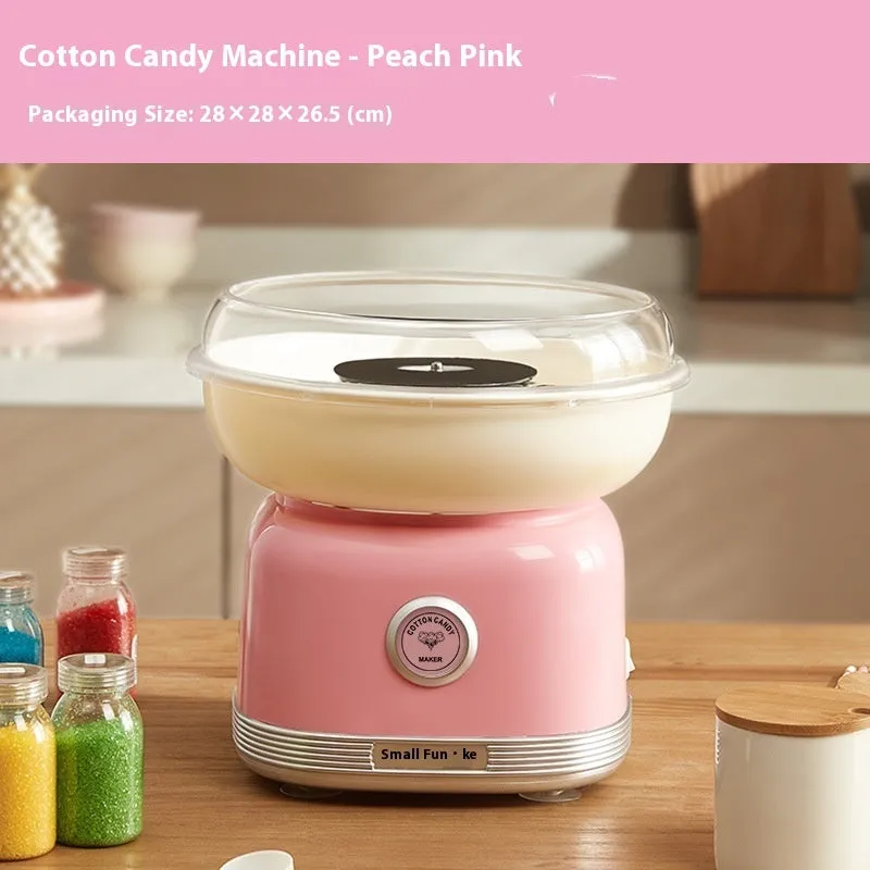 Pink mini electric cotton candy making machine with stainless steel body on a kitchen counter