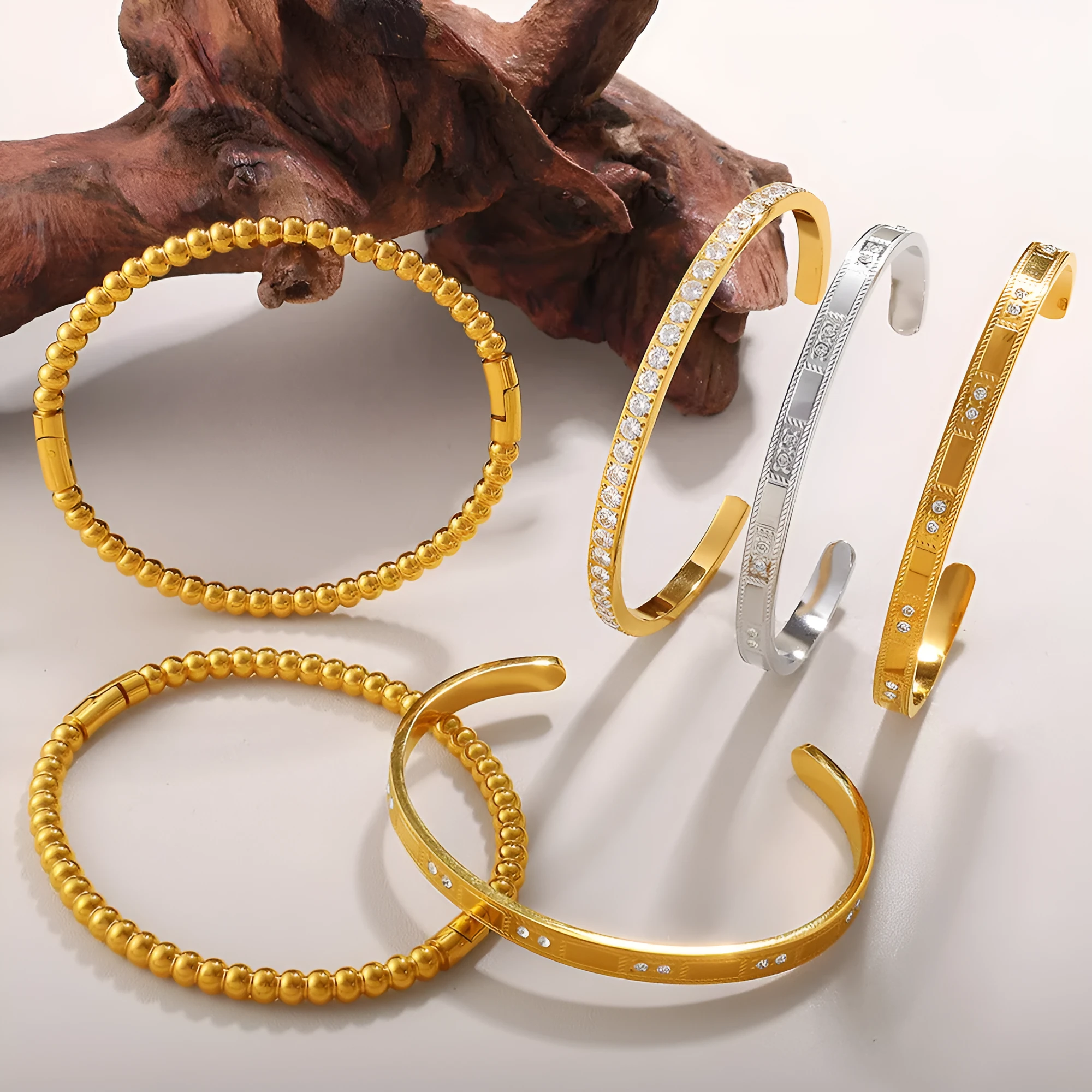 Stainless steel open-end bracelet with a buckle closure and circle design, shown in an electroplated gold colour.