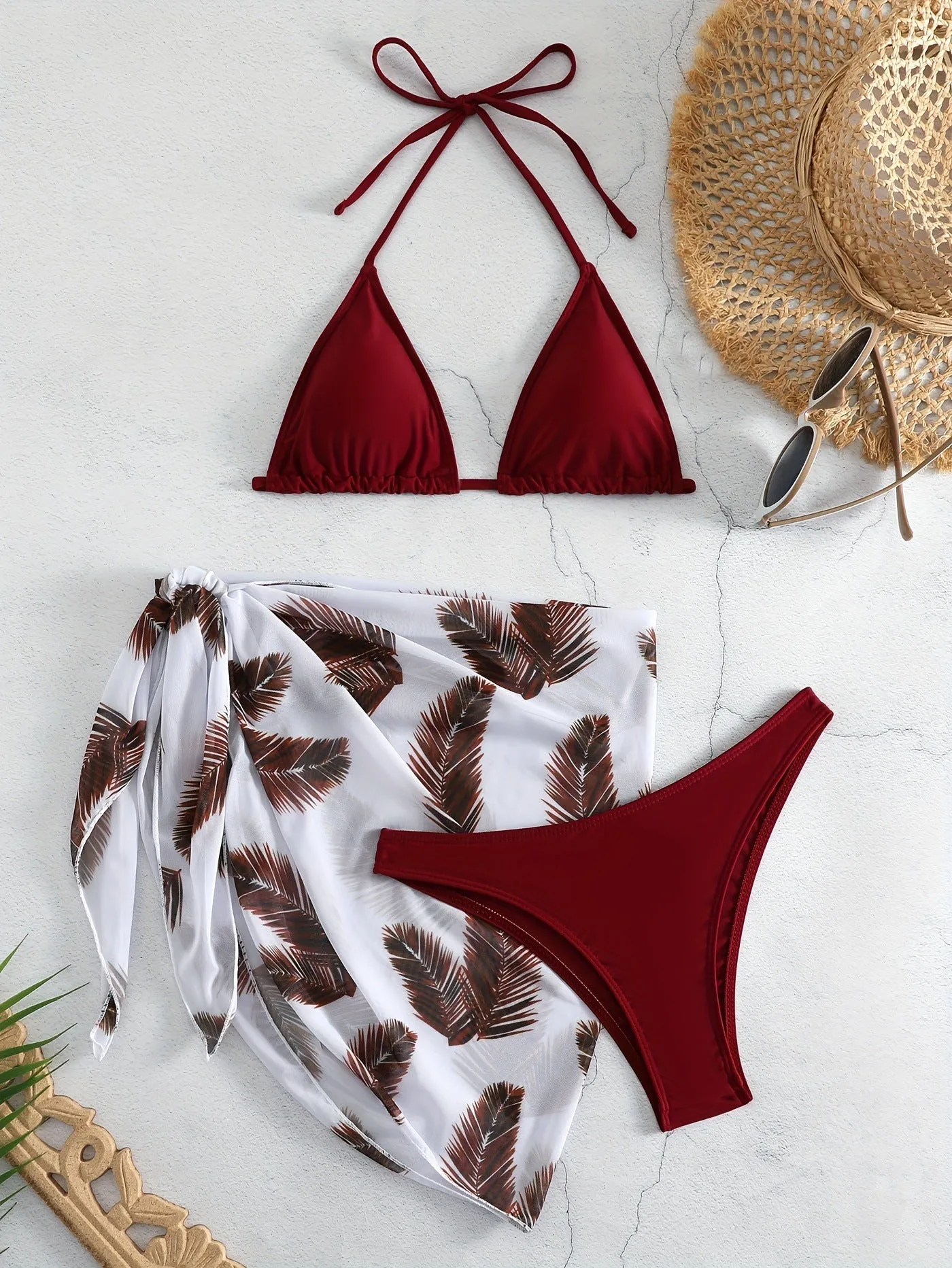 Orange three-piece bikini swimsuit set with a printed gauze skirt on a white background