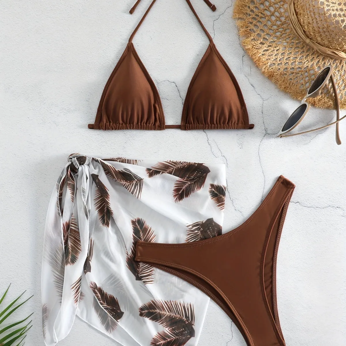 Orange three-piece bikini swimsuit set with a printed gauze skirt on a white background