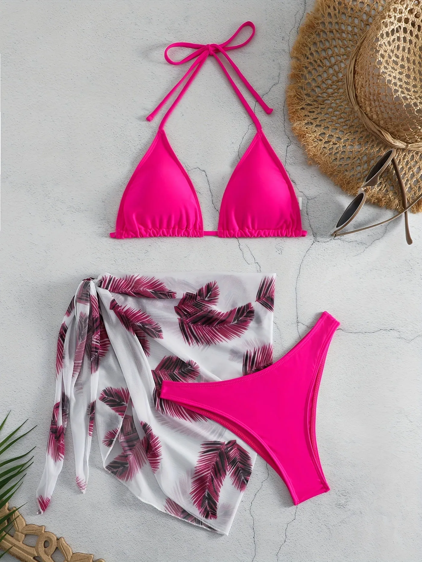 Orange three-piece bikini swimsuit set with a printed gauze skirt on a white background
