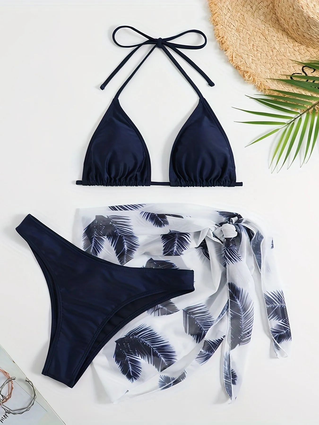 Orange three-piece bikini swimsuit set with a printed gauze skirt on a white background