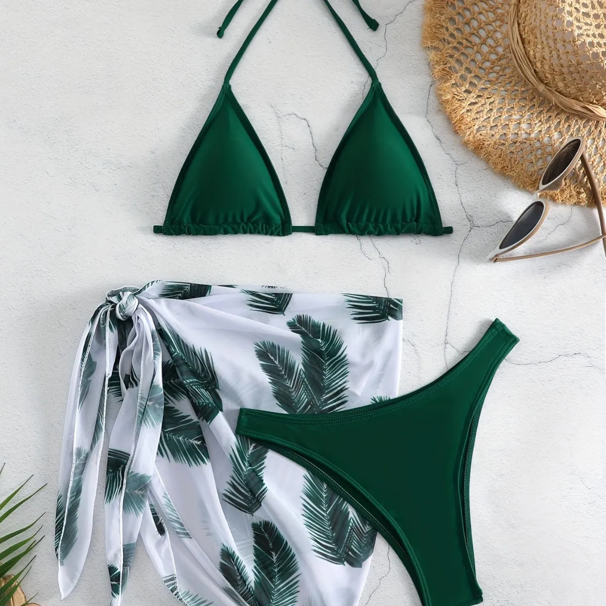 Orange three-piece bikini swimsuit set with a printed gauze skirt on a white background