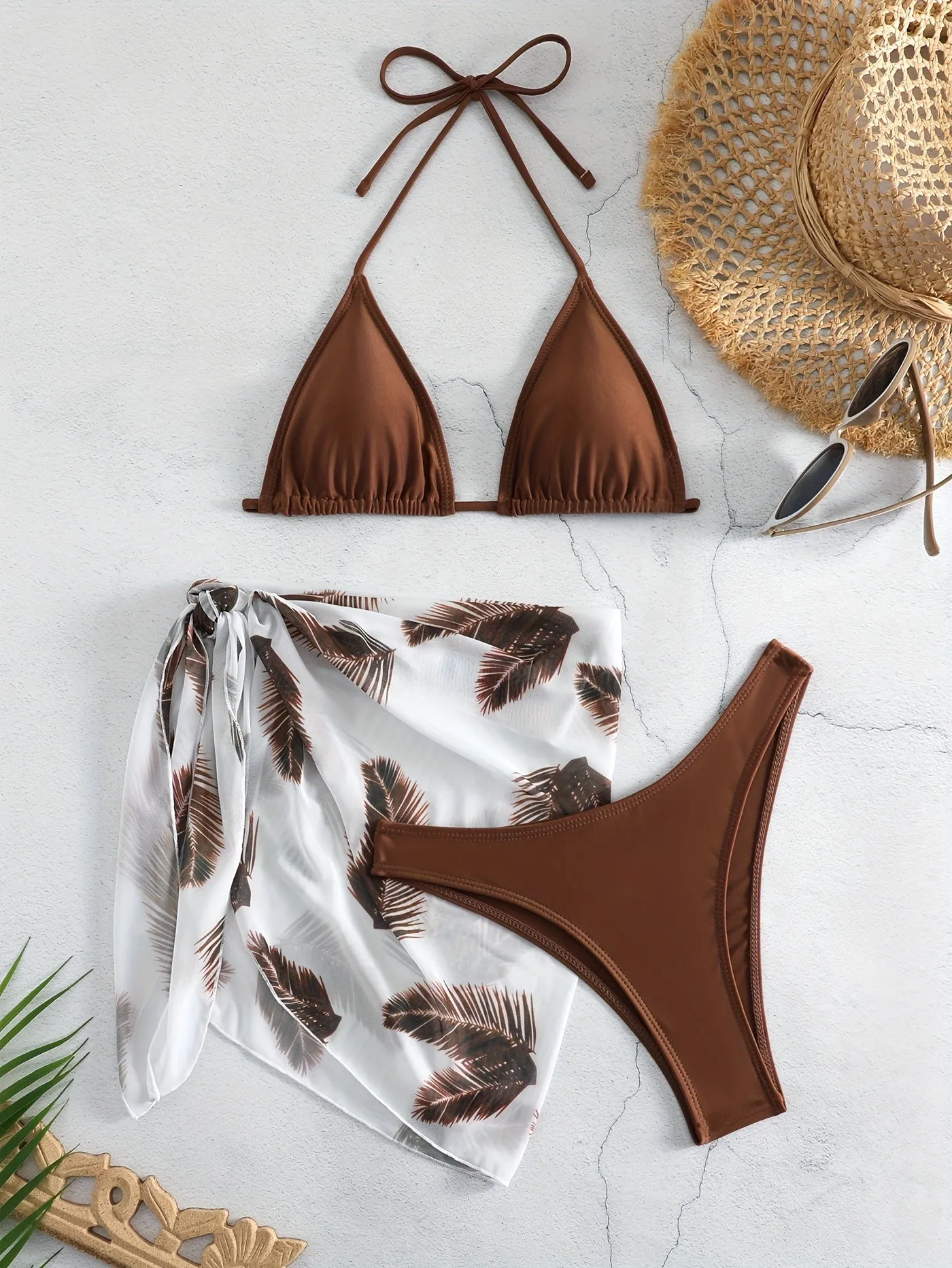 Orange three-piece bikini swimsuit set with a printed gauze skirt on a white background