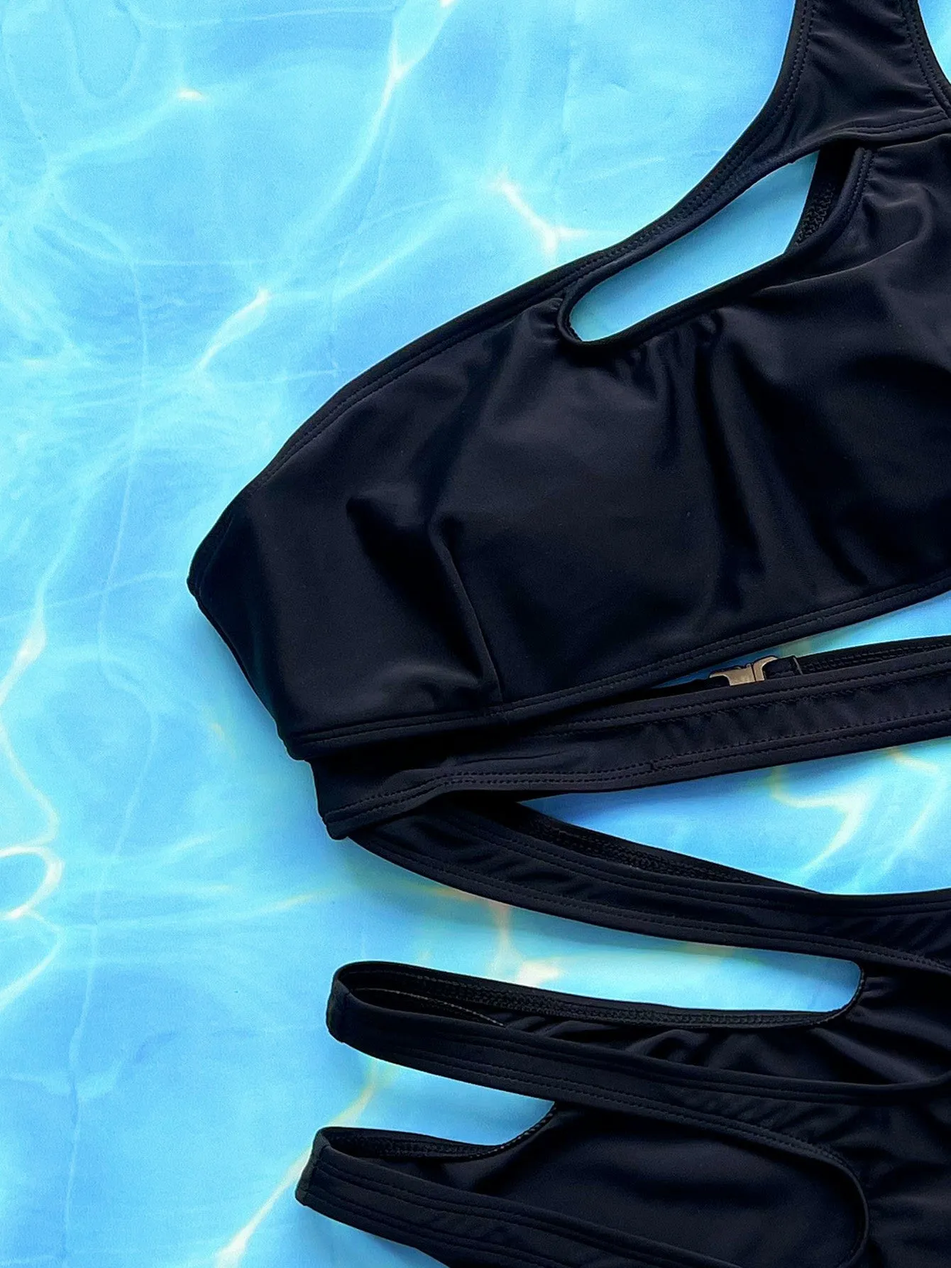 Black women's one-piece swimsuit with hollow out strap design on mannequin