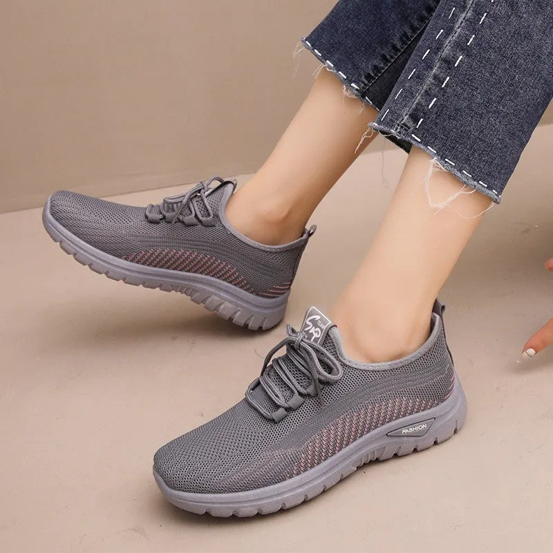 Women's black mesh sneakers with round toe and cross strap detail on rubber sole
